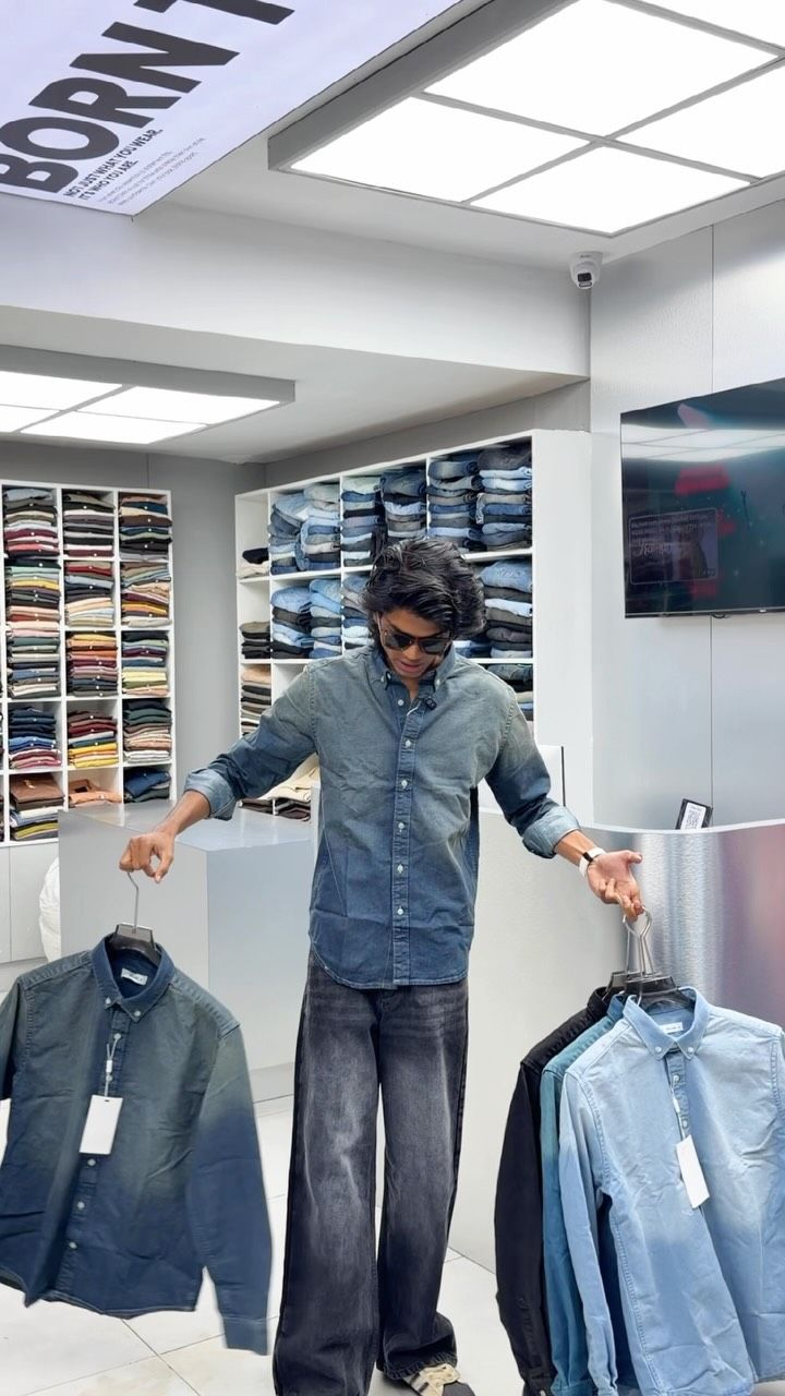 Model in a denim shirt and baggy jeans holding denim shirts at Borntown
