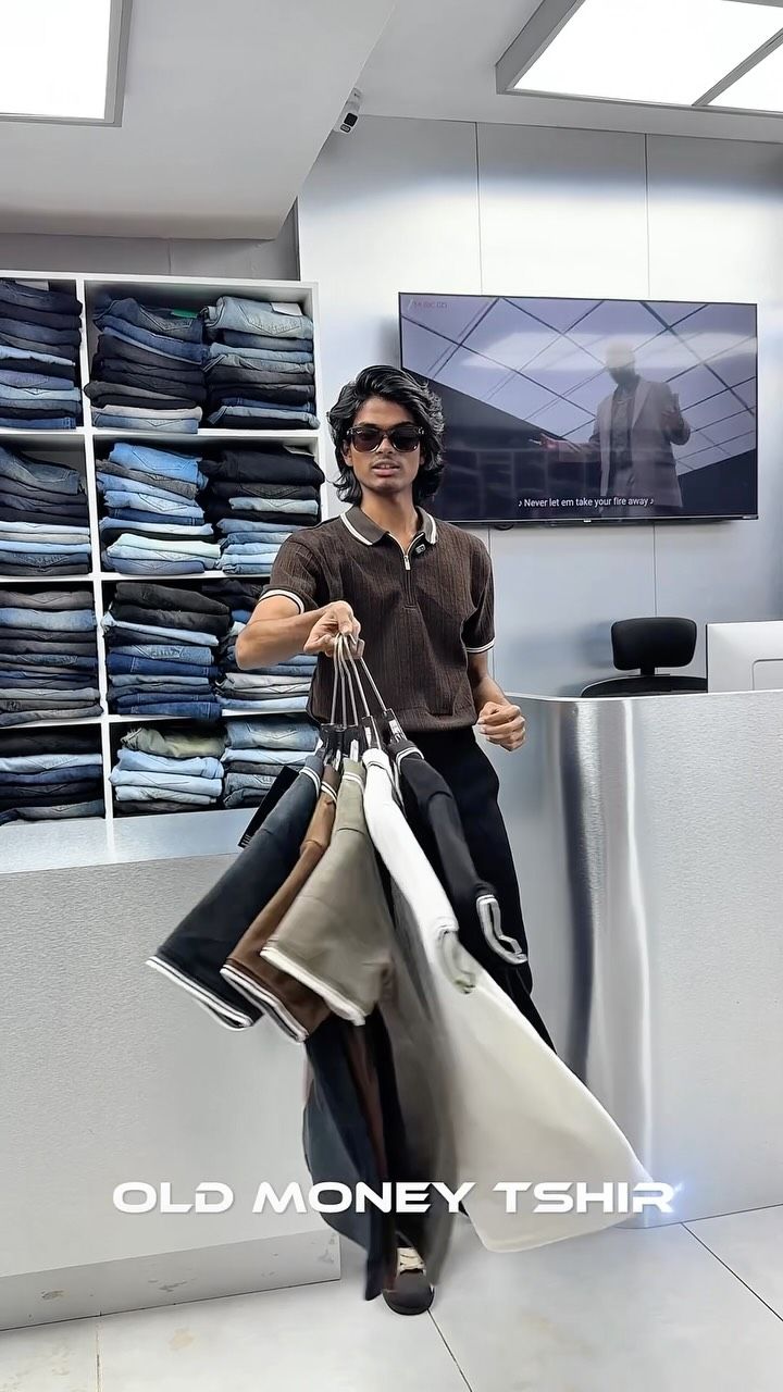Model in a brown knit polo holding a bunch of old money polos