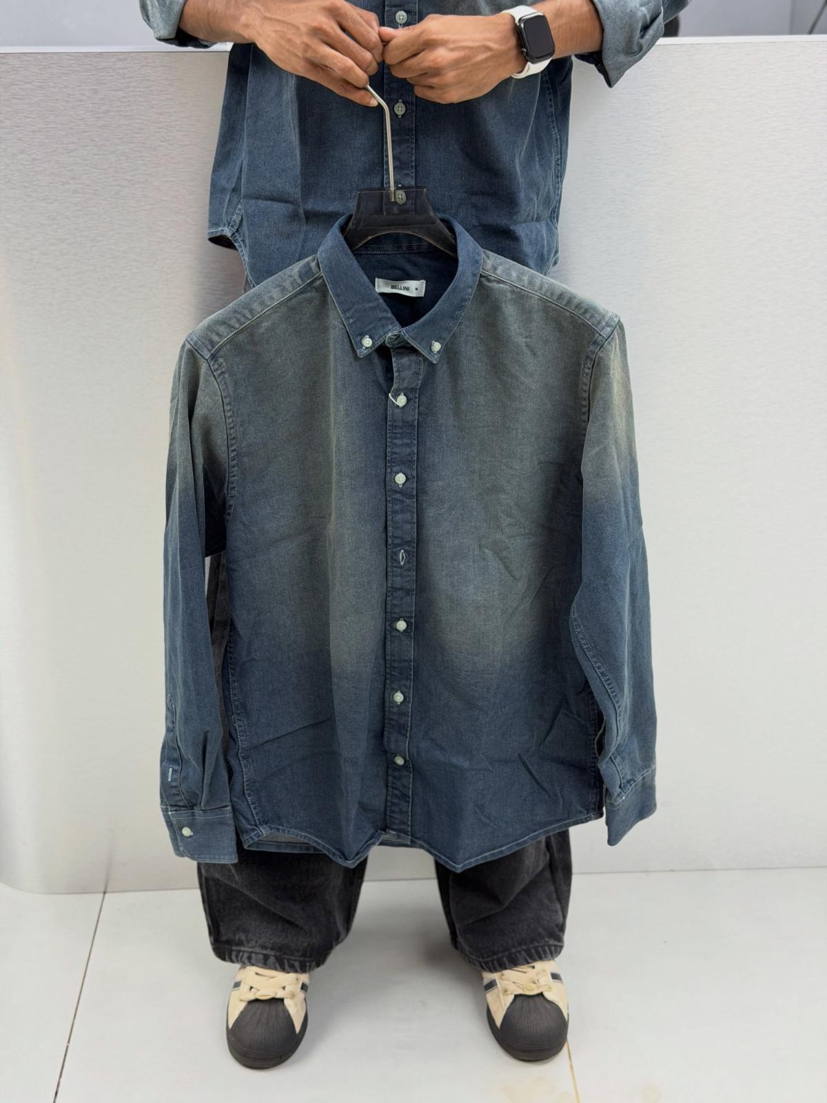 Vintage wash denim shirt held on a hanger